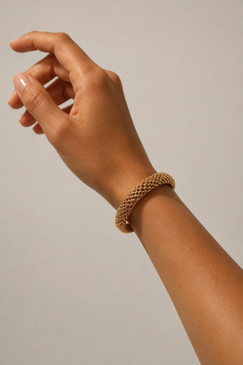 Brazalete de malla dorada puesto en la muñeca