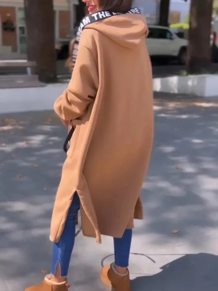 Giorgia en camel, de espaldas con la capucha puesta